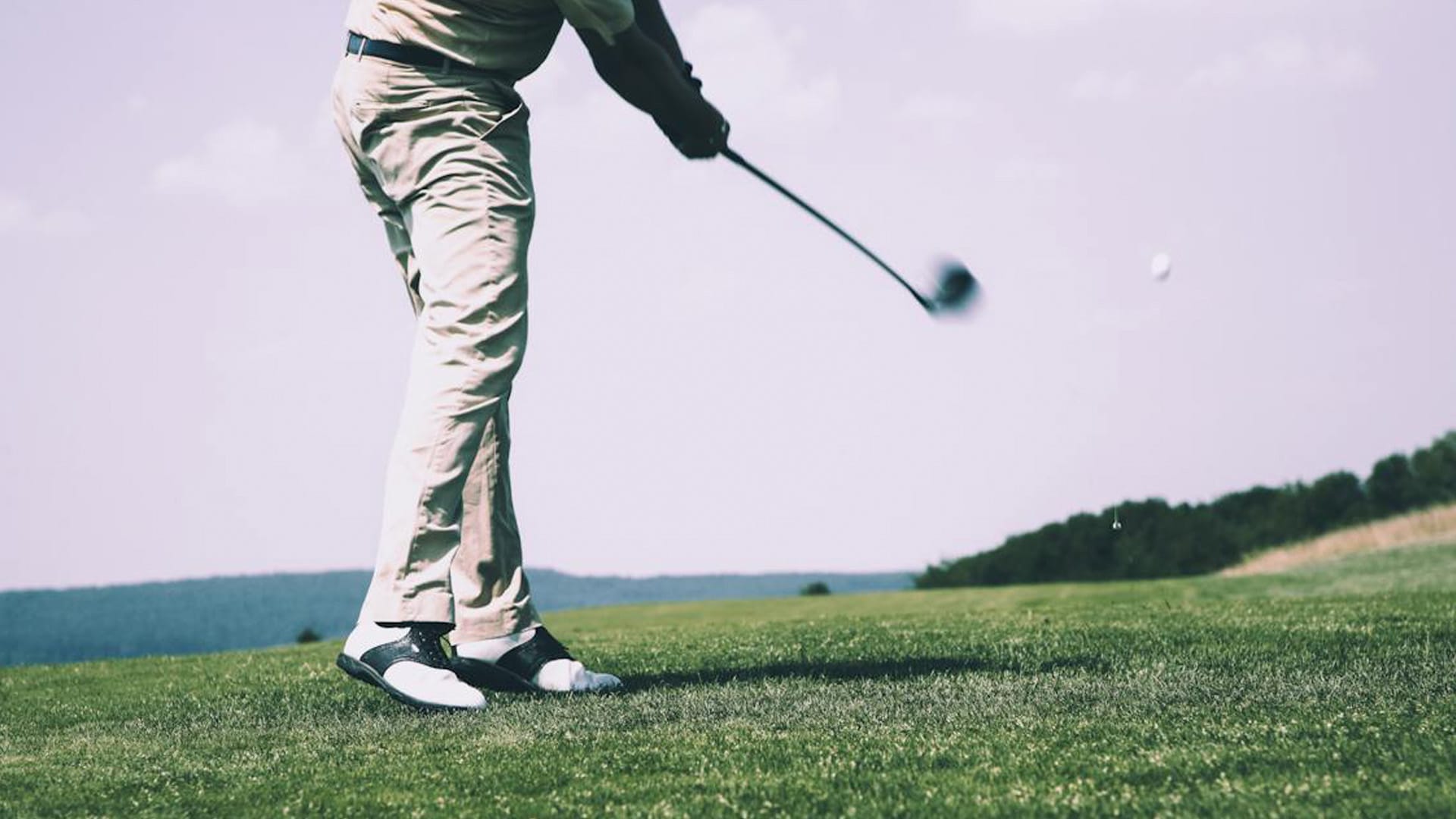 A golfer striking a golf ball