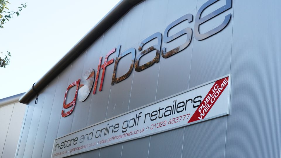 Photograph of the side of Golfbase HQ showing the company logo and contact info