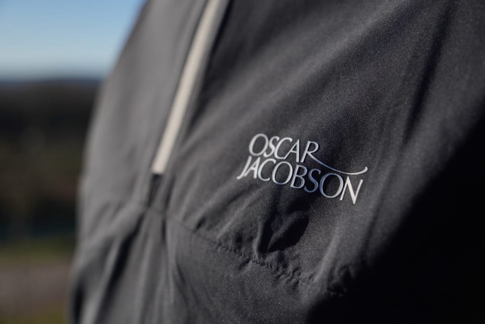 The Oscar Jacobson logo on a golf jacket