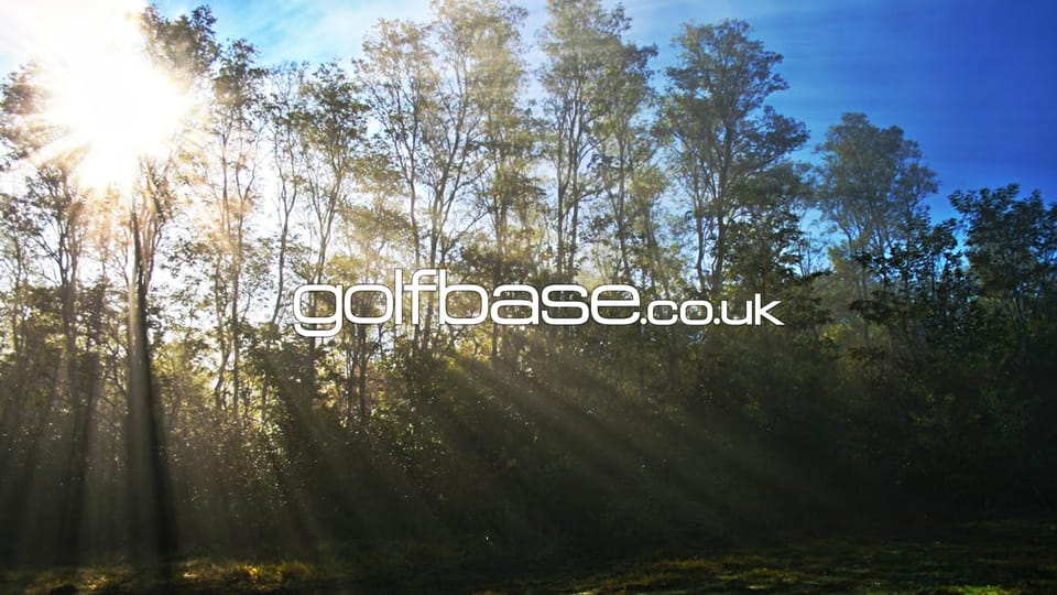 Sunrays pouring through the trees with the Golfbase.co.uk logo in the centre of the image.